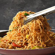 A fork resting on a plate of noodles, representing the exquisite flavors of Indian and Nepali dishes from a top restaurant.