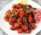 A tempting plate of chicken wings accompanied by onions and lemon, representing the finest Indian and Nepali flavors.