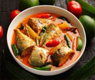 A vibrant bowl of fish and vegetables, featuring fresh tomatoes, representing Indian and Nepali cuisine at a top restaurant.