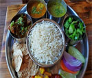 A plate brimming with rice, fresh vegetables, and assorted dishes, celebrating the rich flavors of Indian and Nepali cuisine.