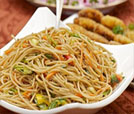 A colorful bowl of noodles with assorted vegetables, representing the culinary delights of Indian and Nepali dishes.