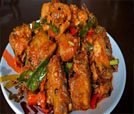 A gourmet plate of chicken wings and peppers, representing the finest offerings from an Indian and Nepali restaurant.