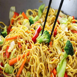 A delicious wok filled with noodles and assorted vegetables, representing the culinary excellence of Indian and Nepali dishes.